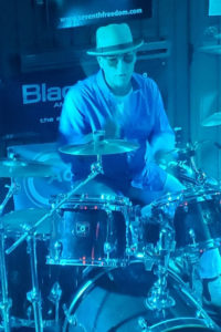 Darren-T-Elliott-playing-drums-on-cherry-red-gretsch-set